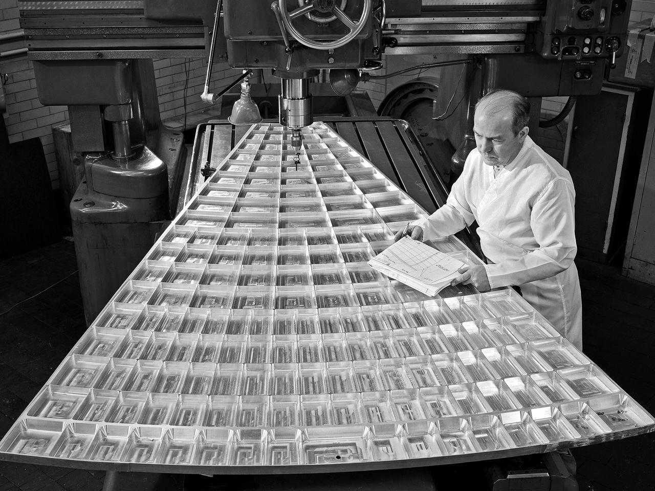 NASA engineer checks specs on a mold in the 1960s.